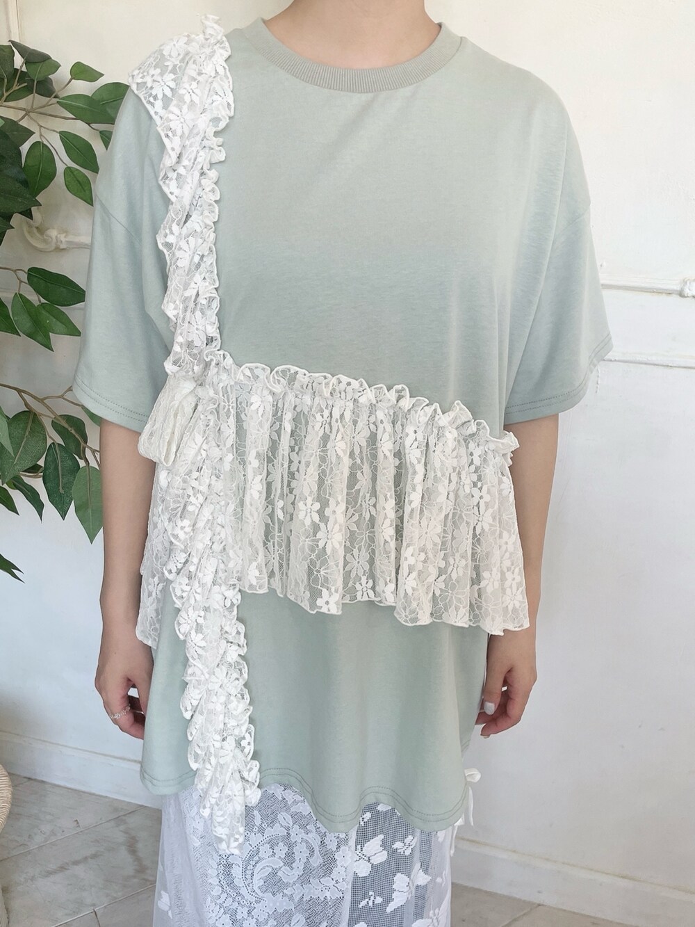 グリーン系のTシャツ/カットソー、ブルー系のデニムパンツ、ホワイト系のスカートを着用したレディースの春コーディネートの7枚目の写真