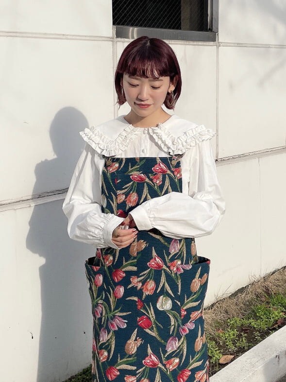 ホワイト系のブーツ、ブルー系のジャンパースカート、ホワイト系のカーディガン/ボレロを着用したレディースの冬コーディネートの5枚目の写真