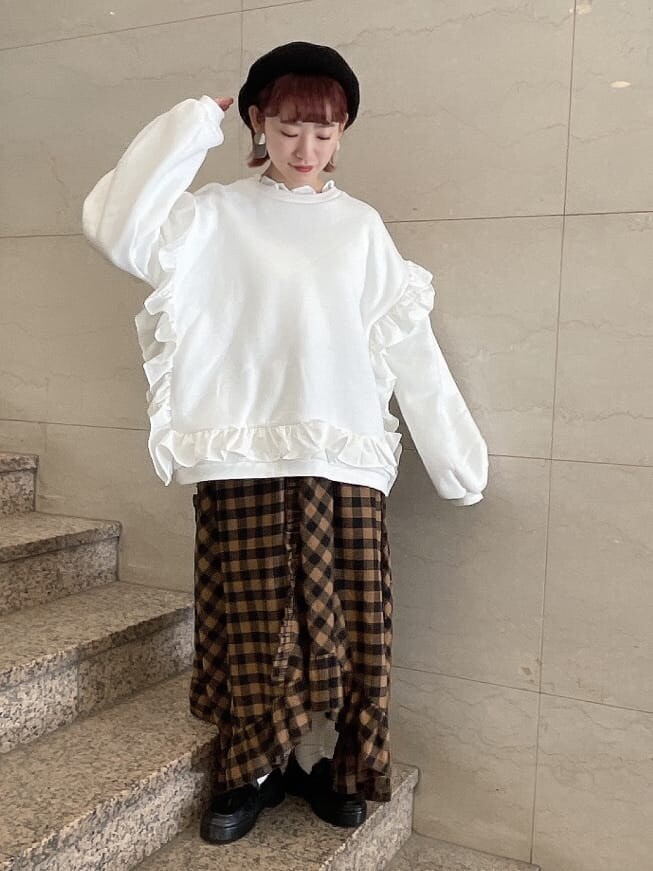 オレンジ系のスカート、ブラック系のローファー、ホワイト系のTシャツ/カットソーを着用したレディースの冬コーディネートの2枚目の写真