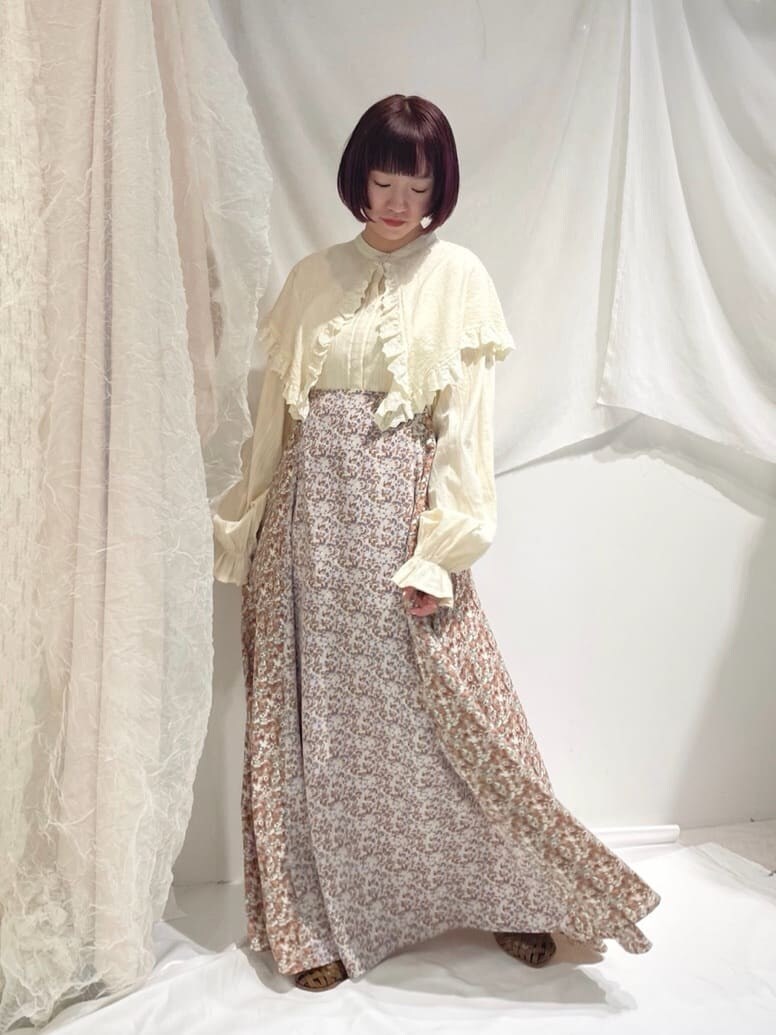 イエロー系のシャツ/ブラウス、ホワイト系のスカート、ベージュ系のパンプスを着用したレディースの春コーディネートの2枚目の写真