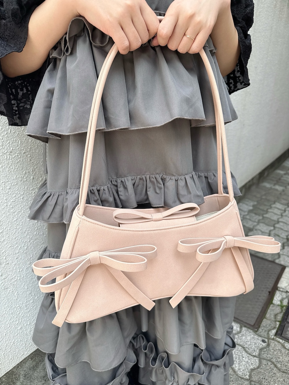 グレー系のワンピース、ブラック系のカーディガン/ボレロ、ピンク系のハンドバッグを着用したレディースの春コーディネートの9枚目の写真