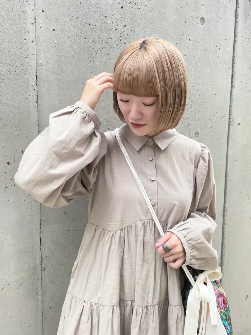 ブラウン系のハンドバッグ、ベージュ系のワンピース、グレー系のサンダルを着用したレディースの夏コーディネートの5枚目の写真