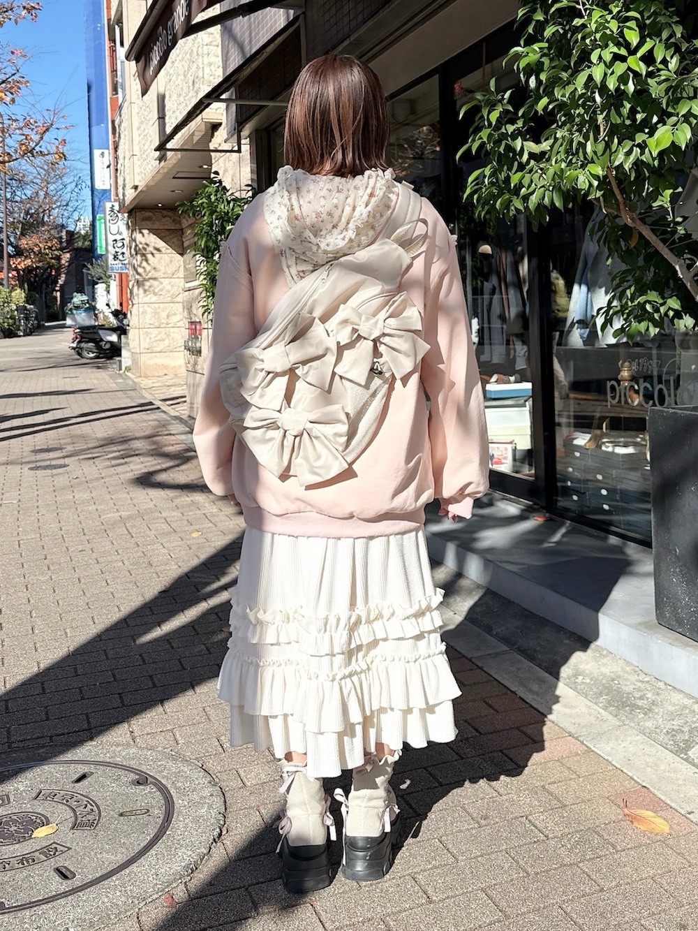 ピンク系のスウェット、ホワイト系のTシャツ/カットソー、ホワイト系のスカートを着用したレディースの冬コーディネートの2枚目の写真