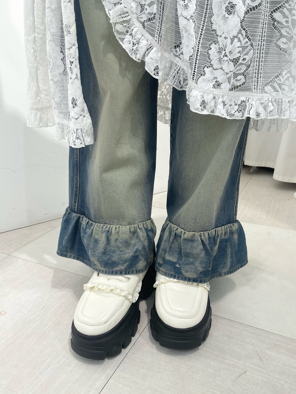 ホワイト系のスウェット、ホワイト系のスカート、ブルー系のデニムパンツを着用したレディースの秋コーディネートの9枚目の写真