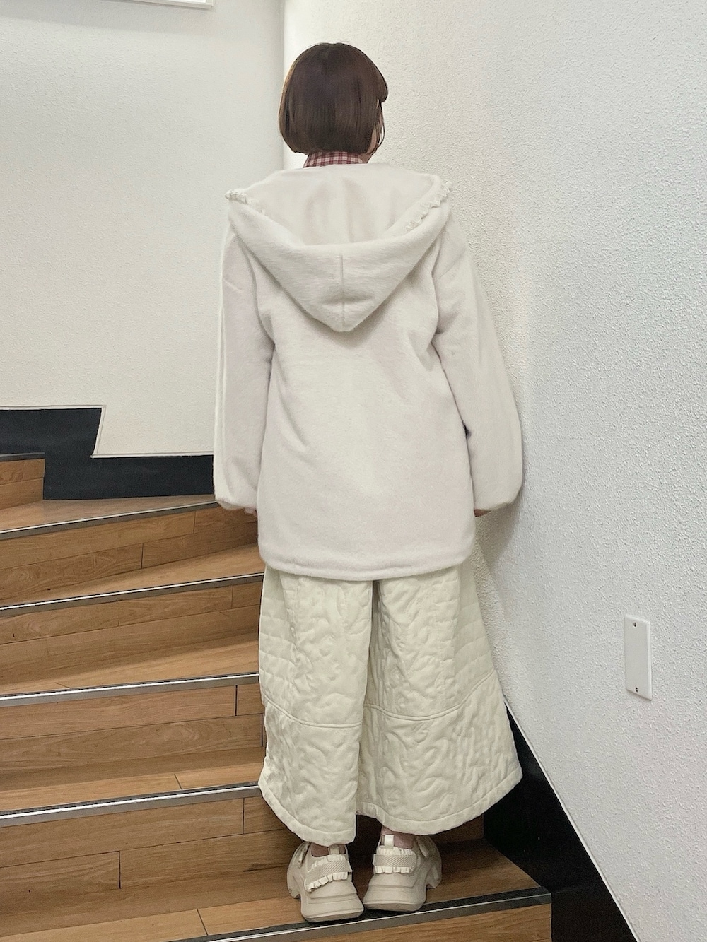 ホワイト系のダウンジャケット/コート、レッド系のシャツ/ブラウス、ホワイト系のワンピースを着用したレディースの冬コーディネートの3枚目の写真