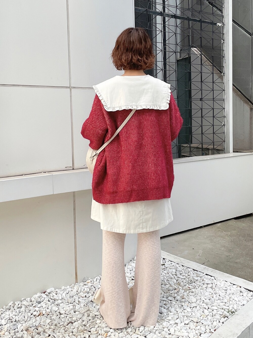 ホワイト系のワンピース、レッド系のカーディガン/ボレロ、ホワイト系のハンドバッグを着用したレディースの秋コーディネートの4枚目の写真