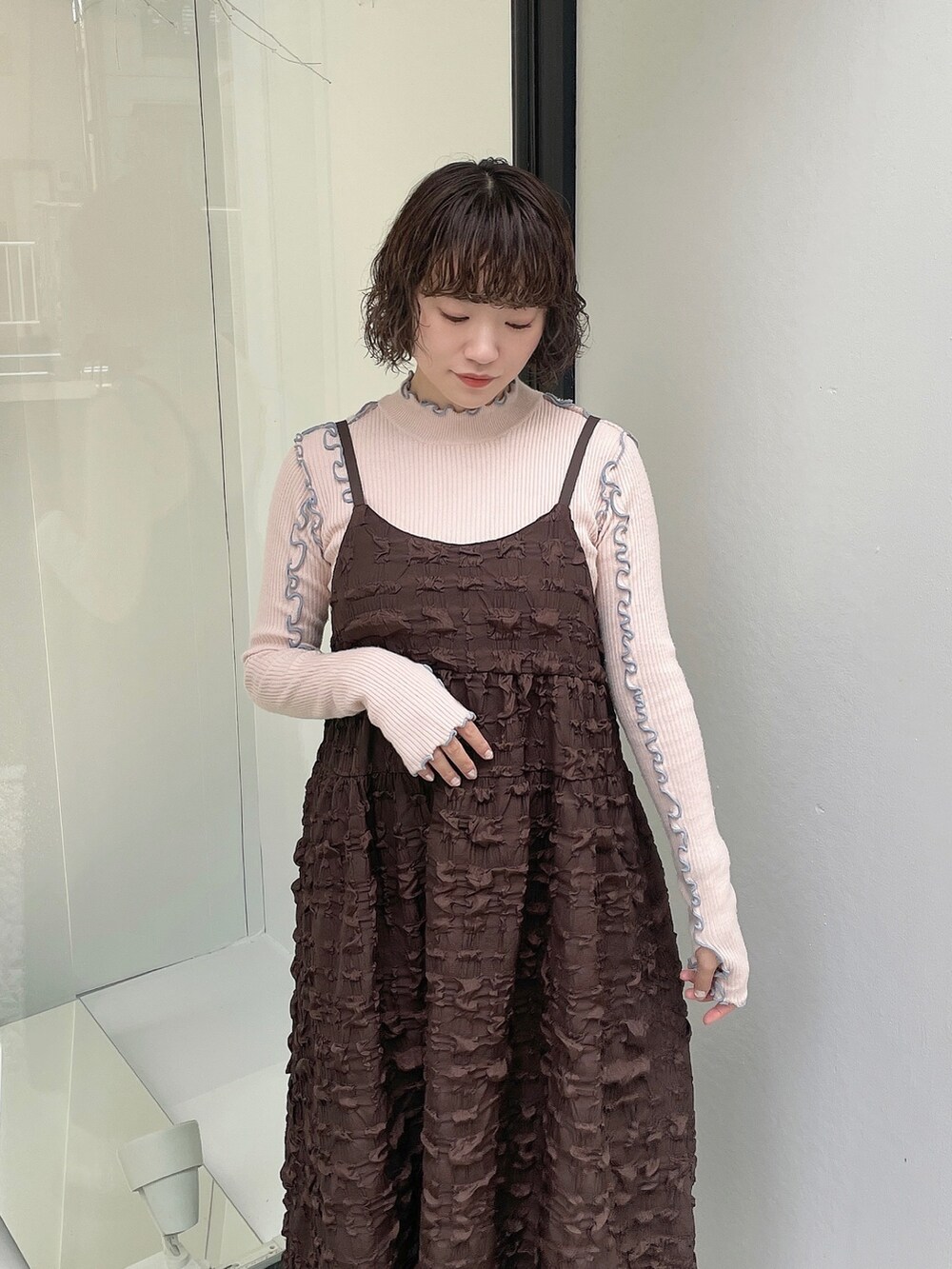 ピンク系のニット/セーター、ホワイト系のカーディガン/ボレロ、ブラウン系のワンピースを着用したレディースの秋コーディネートの8枚目の写真