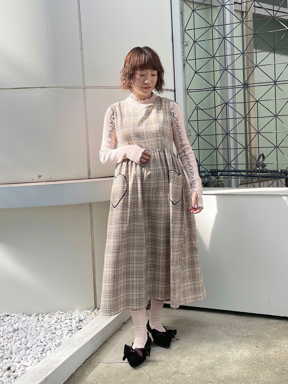 ピンク系のニット/セーター、ブラック系のデニムジャケット、ベージュ系のワンピースを着用したレディースの夏コーディネートの4枚目の写真