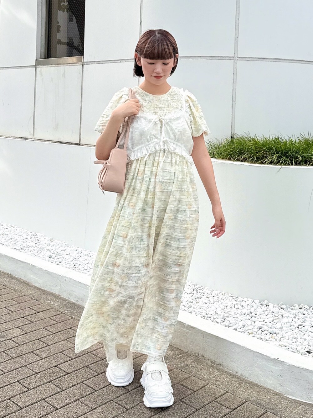 イエロー系のワンピース、ホワイト系のシャツ/ブラウス、ホワイト系のスニーカーを着用したレディースの夏コーディネートの2枚目の写真