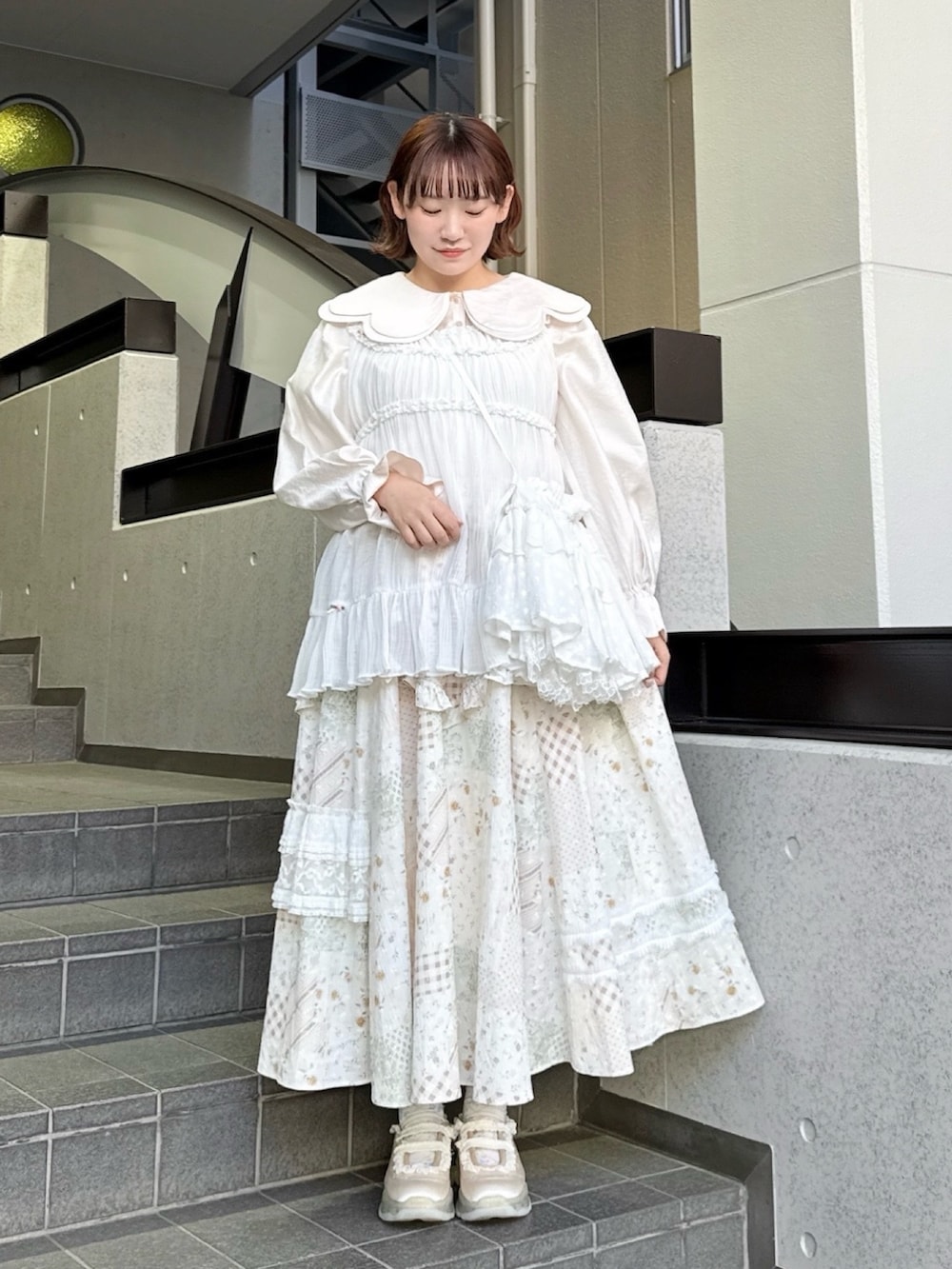 ピンク系のシャツ/ブラウス、ホワイト系のスカート、ホワイト系のショルダーバッグを着用したレディースの春コーディネートの2枚目の写真