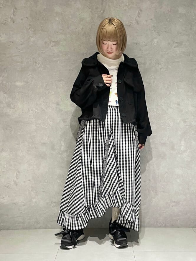 ブラック系のテーラードジャケット、ホワイト系のTシャツ/カットソー、ブラック系のスカートを着用したレディースの秋コーディネートの2枚目の写真