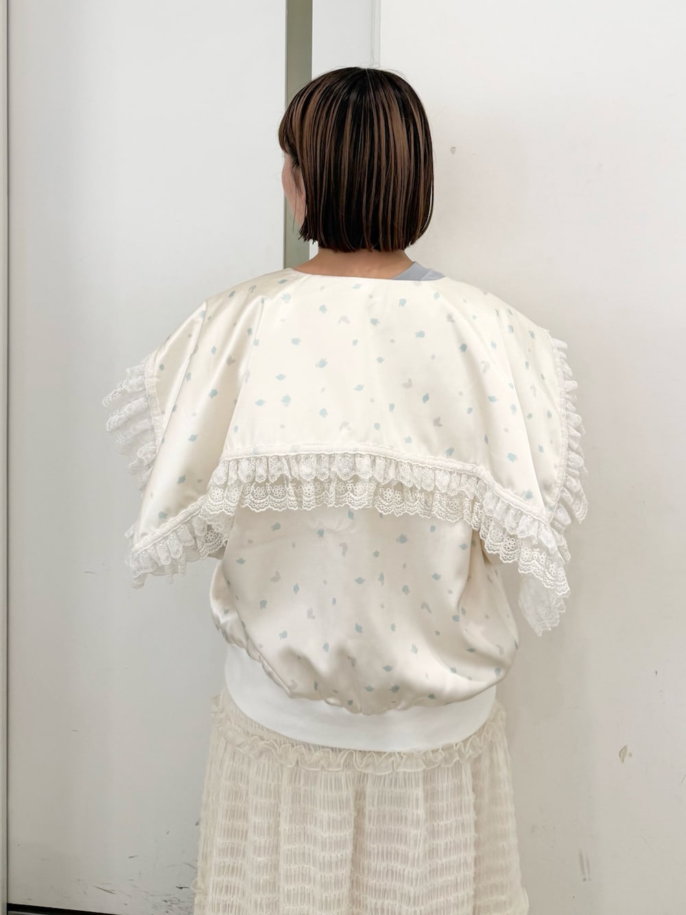 ブルー系のブルゾン、ブルー系のTシャツ/カットソー、ホワイト系のスカートを着用したレディースの夏コーディネートの5枚目の写真