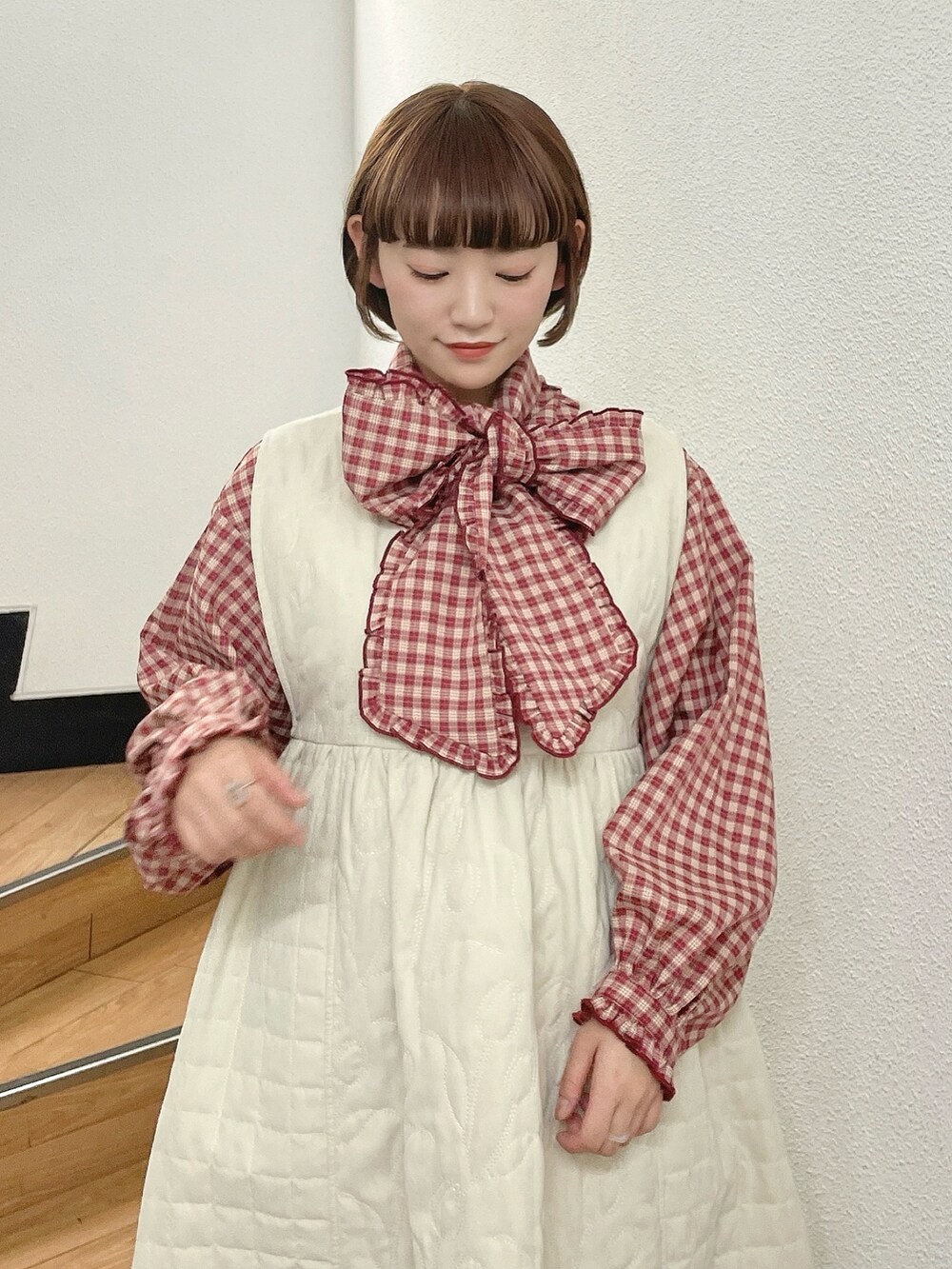 ホワイト系のダウンジャケット/コート、レッド系のシャツ/ブラウス、ホワイト系のワンピースを着用したレディースの冬コーディネートの9枚目の写真