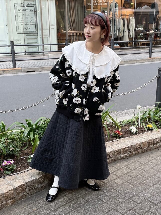ブラック系のパンプス、ブラック系のその他アウター、ホワイト系のシャツ/ブラウスを着用したレディースの冬コーディネートの2枚目の写真