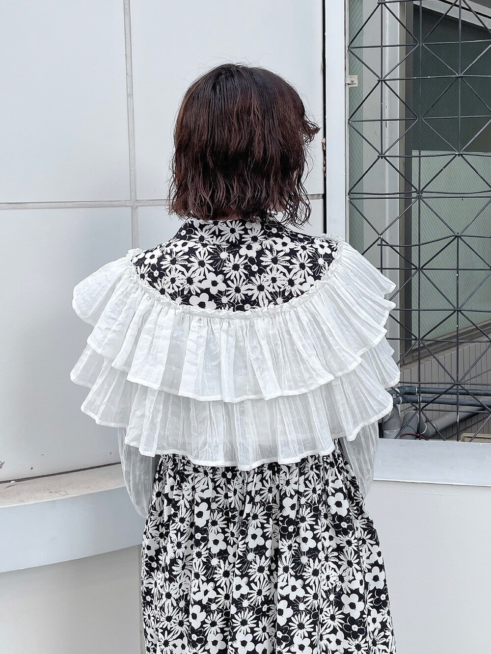 ブラック系のワンピース、ホワイト系のシャツ/ブラウス、ホワイト系のパンプスを着用したレディースの秋コーディネートの5枚目の写真