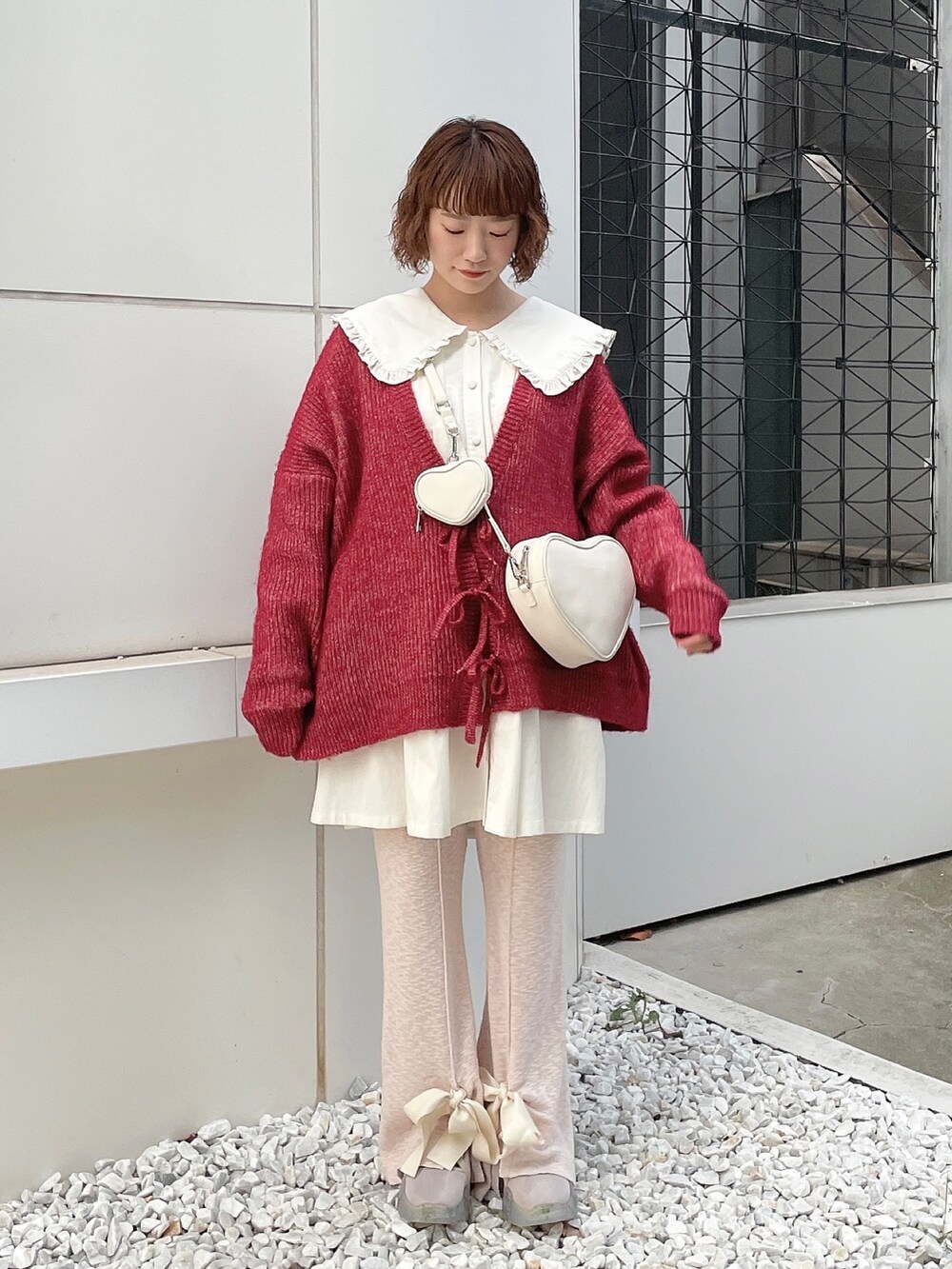 ホワイト系のワンピース、レッド系のカーディガン/ボレロ、ホワイト系のハンドバッグを着用したレディースの秋コーディネートの3枚目の写真