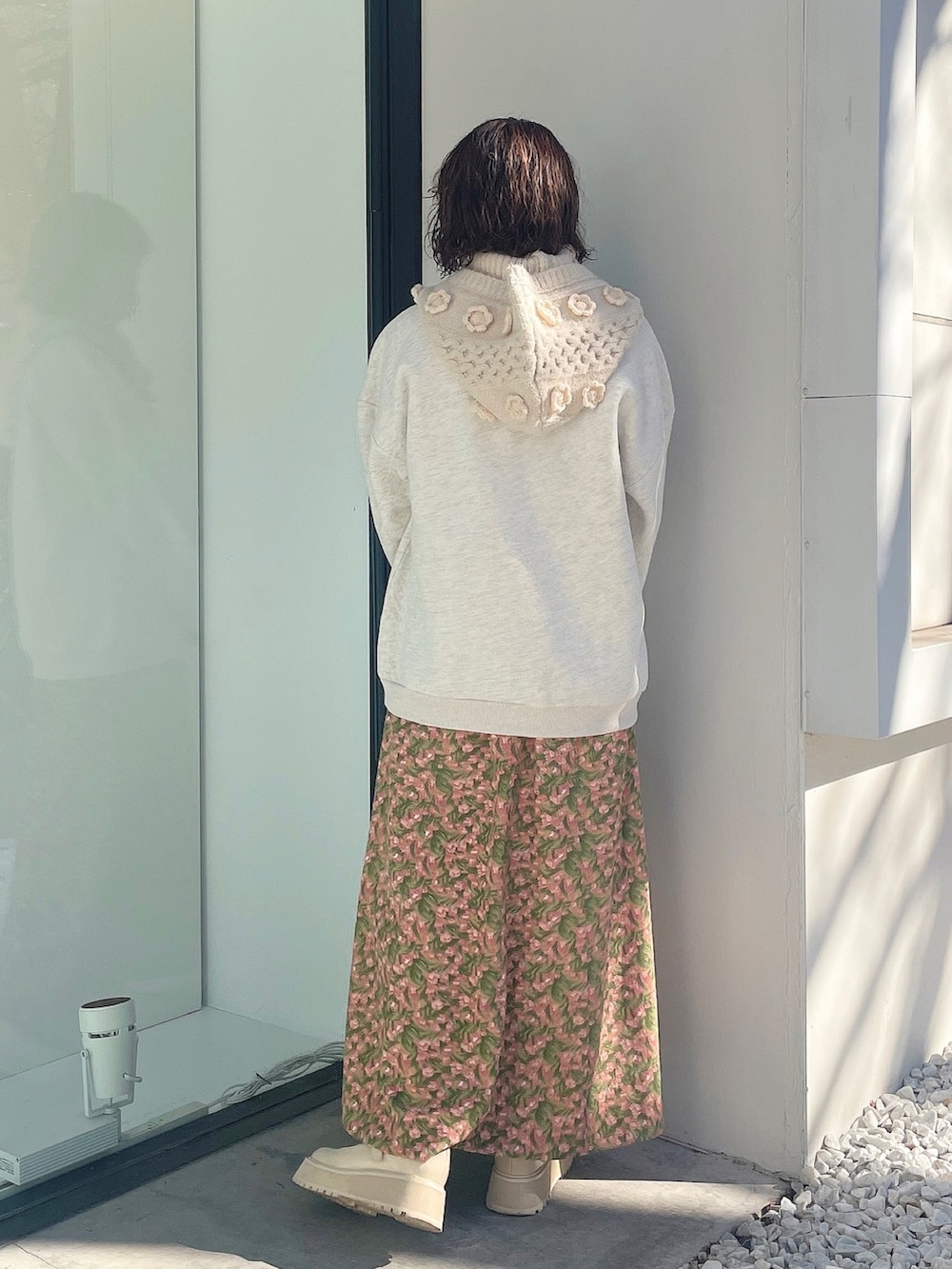 オレンジ系のワンピース、ホワイト系のスウェット、ホワイト系のローファーを着用したレディースの冬コーディネートの2枚目の写真