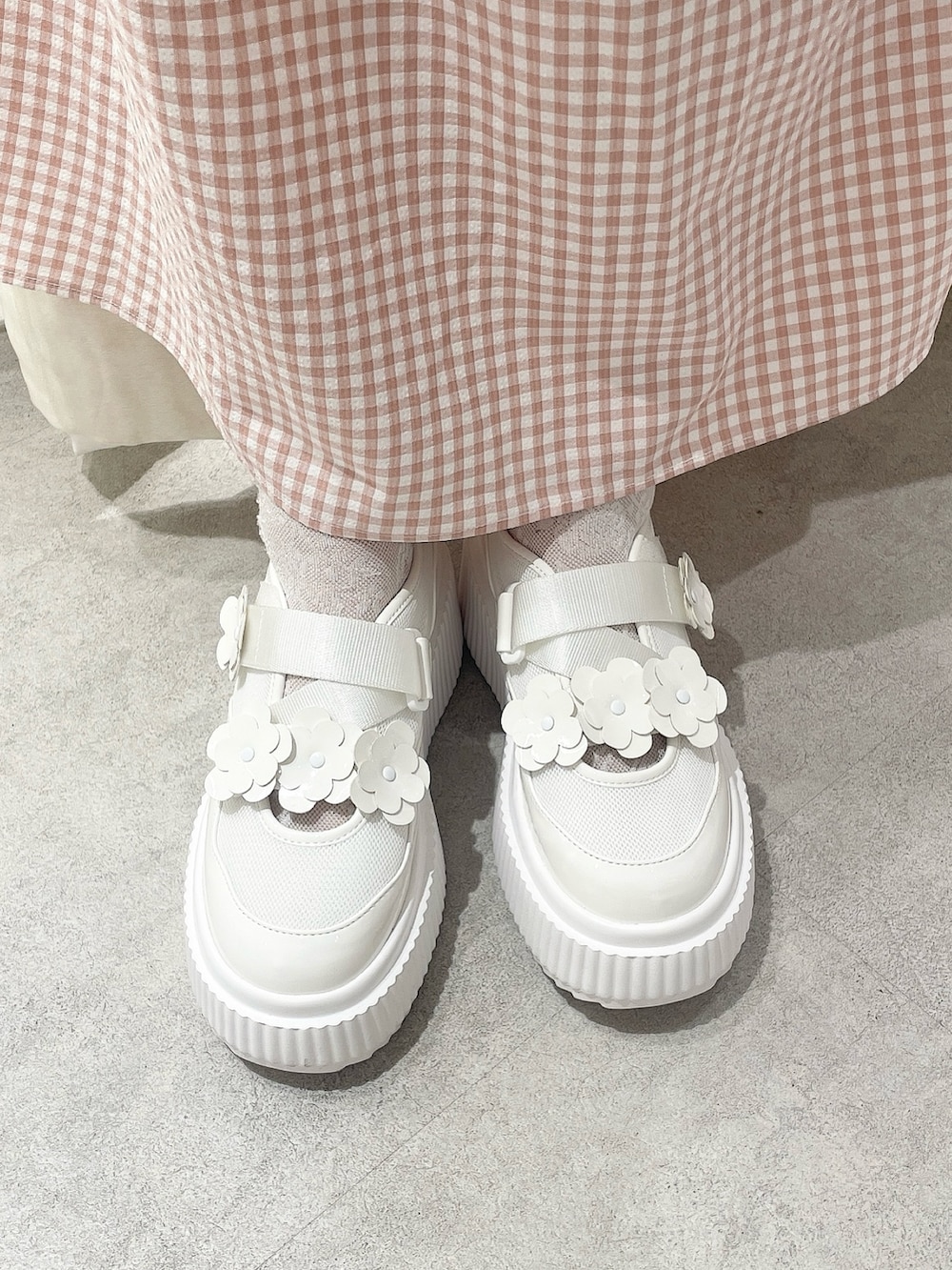 ピンク系のカーディガン/ボレロ、ピンク系のワンピース、ホワイト系のスニーカーを着用したレディースの冬コーディネートの6枚目の写真