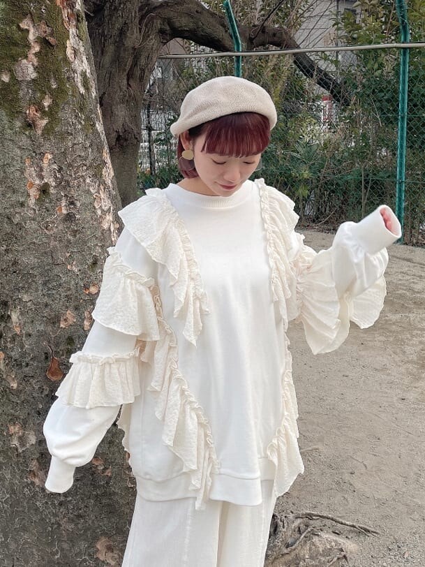 ホワイト系のスニーカー、ピンク系のショルダーバッグ、ホワイト系のスウェットを着用したレディースの冬コーディネートの4枚目の写真