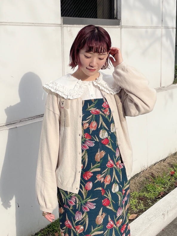 ホワイト系のブーツ、ブルー系のジャンパースカート、ホワイト系のカーディガン/ボレロを着用したレディースの冬コーディネートの3枚目の写真