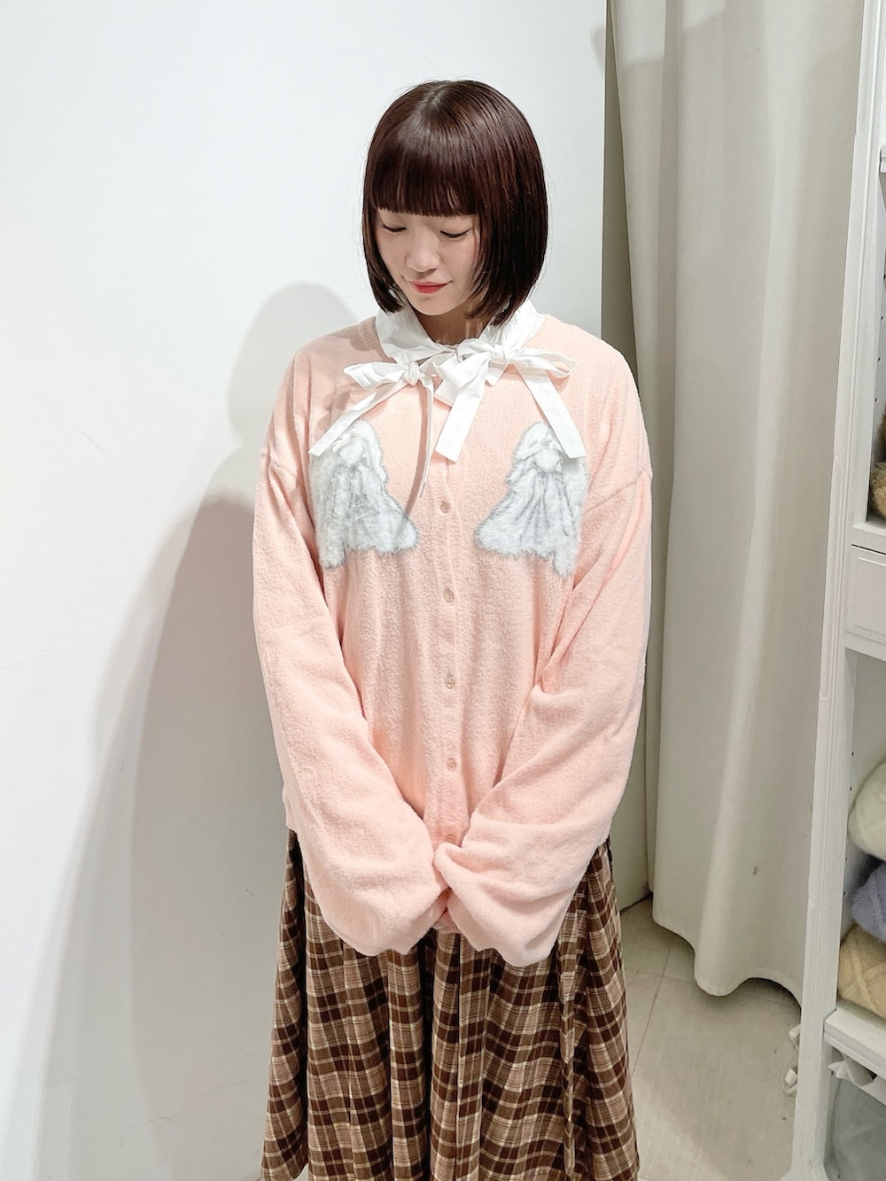 ホワイト系のシャツ/ブラウス、ピンク系のカーディガン/ボレロ、ブラウン系のスカートを着用したレディースの秋コーディネートの4枚目の写真