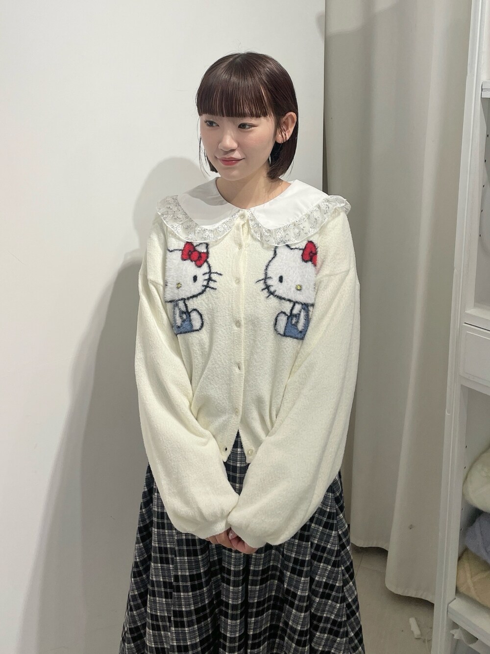 ホワイト系のカーディガン/ボレロ、シルバー系のシャツ/ブラウス、ブラック系のスカートを着用したレディースの秋コーディネートの4枚目の写真