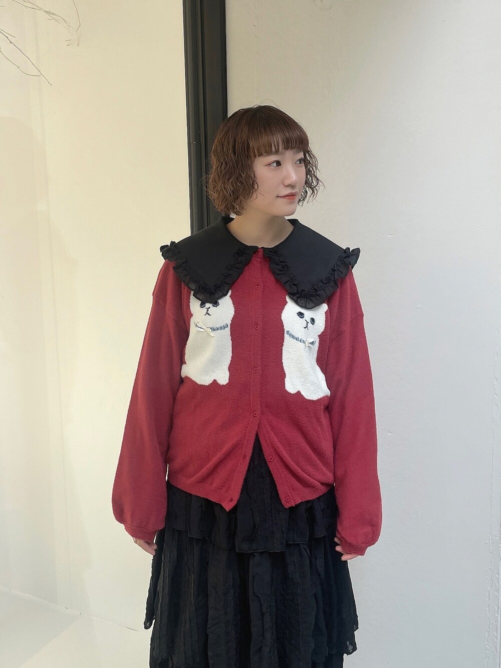 ブラック系のスカート、ブラック系のサンダル、レッド系のカーディガン/ボレロを着用したレディースの夏コーディネートの5枚目の写真