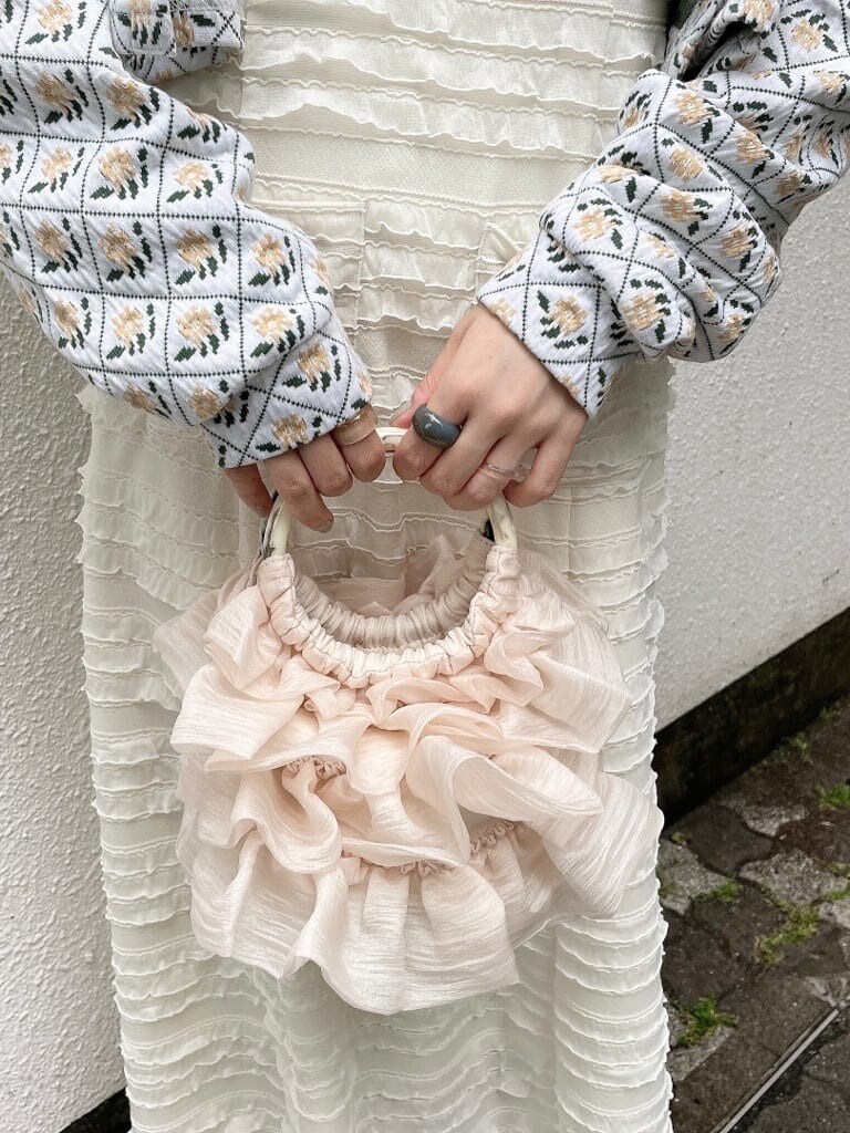 ホワイト系のワンピース、ホワイト系のブーツ、ホワイト系のハンドバッグを着用したレディースの夏コーディネートの6枚目の写真