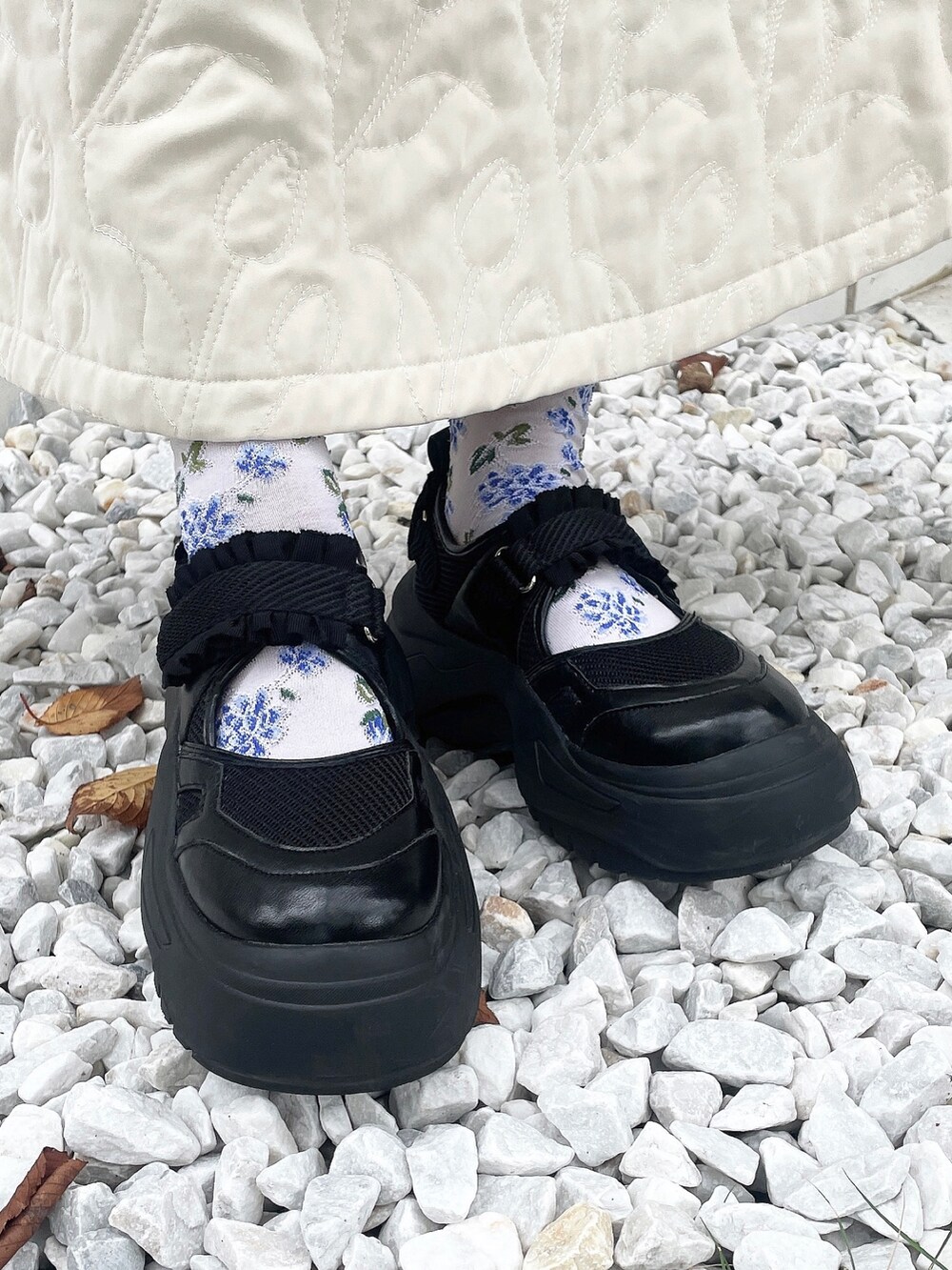 ブラック系のニット/セーター、ホワイト系のハンドバッグ、ホワイト系のスカートを着用したレディースの秋コーディネートの8枚目の写真