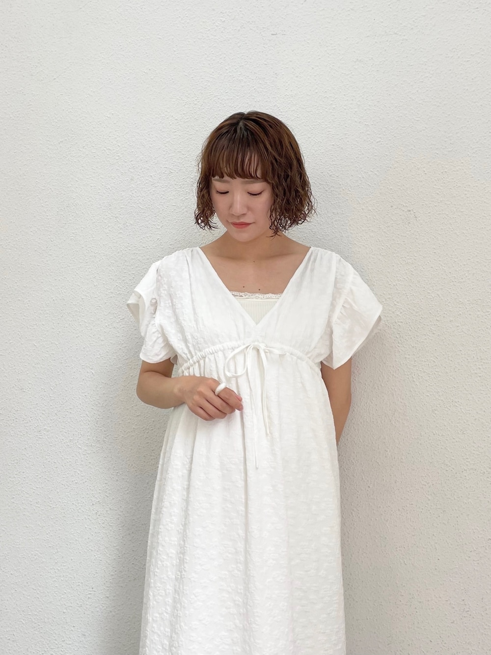 ホワイト系のキャミソール、ホワイト系のワンピース、ゴールド系のパンプスを着用したレディースの春コーディネートの4枚目の写真