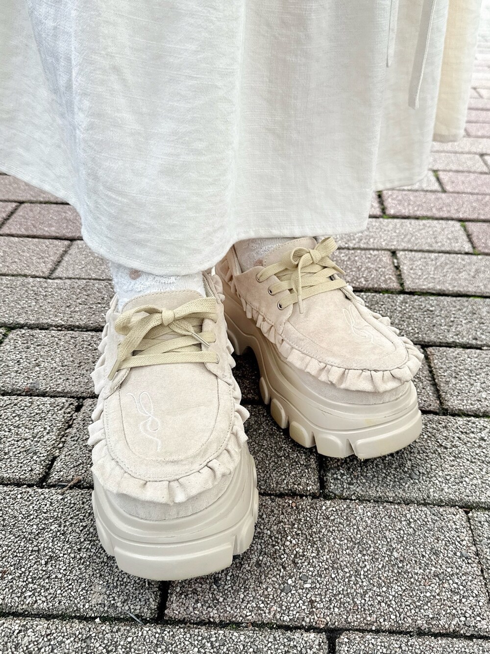 グレー系のカーディガン/ボレロ、ホワイト系のスカート、ホワイト系のショルダーバッグを着用したレディースの夏コーディネートの5枚目の写真