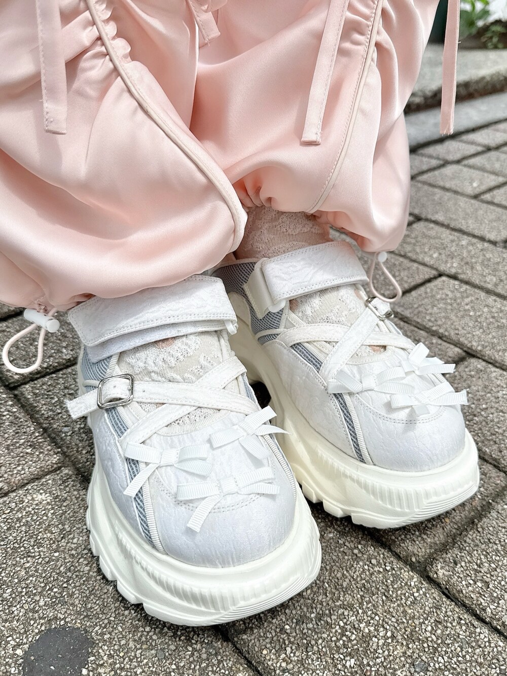 ピンク系のその他パンツ、ホワイト系のショルダーバッグ、グレー系のカーディガン/ボレロを着用したレディースの夏コーディネートの9枚目の写真