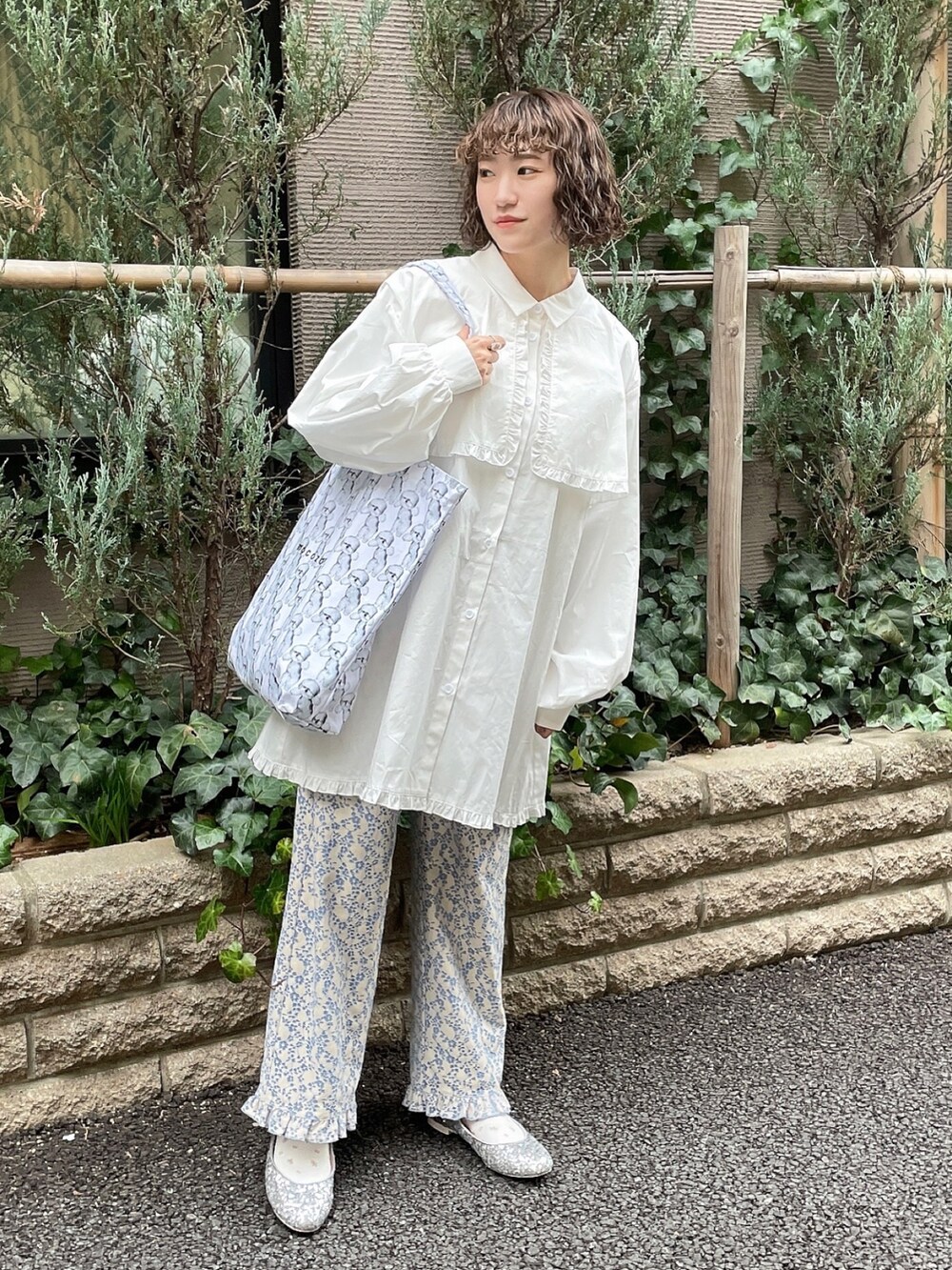 ホワイト系のワンピース、ブルー系のその他パンツ、ホワイト系のトートバッグを着用したレディースの冬コーディネートの2枚目の写真