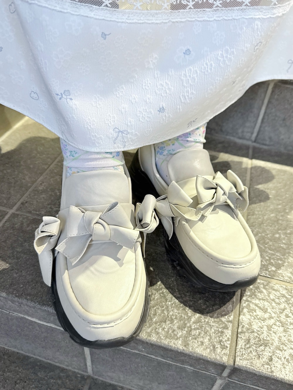 ブルー系のTシャツ/カットソー、ホワイト系のワンピース、ホワイト系のトートバッグを着用したレディースの冬コーディネートの9枚目の写真