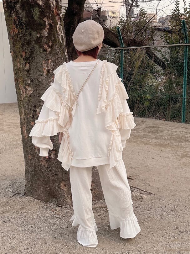 ホワイト系のスニーカー、ピンク系のショルダーバッグ、ホワイト系のスウェットを着用したレディースの冬コーディネートの3枚目の写真