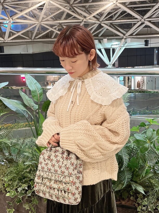 ベージュ系のスカート、ホワイト系のローファー、グリーン系のショルダーバッグを着用したレディースの冬コーディネートの4枚目の写真