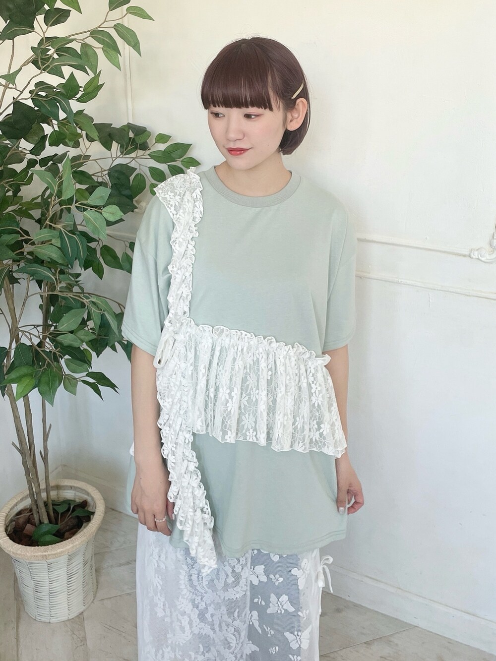 グリーン系のTシャツ/カットソー、ブルー系のデニムパンツ、ホワイト系のスカートを着用したレディースの春コーディネートの4枚目の写真