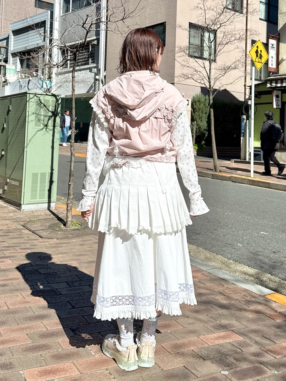 ピンク系のベスト、ピンク系のTシャツ/カットソー、ホワイト系のスカートを着用したレディースの春コーディネートの3枚目の写真