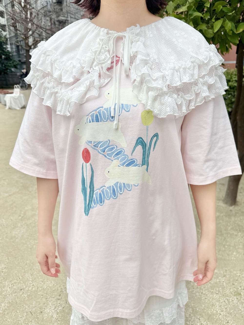 ピンク系のTシャツ/カットソー、ホワイト系のかごバッグ、ホワイト系のスニーカーを着用したレディースの春コーディネートの6枚目の写真