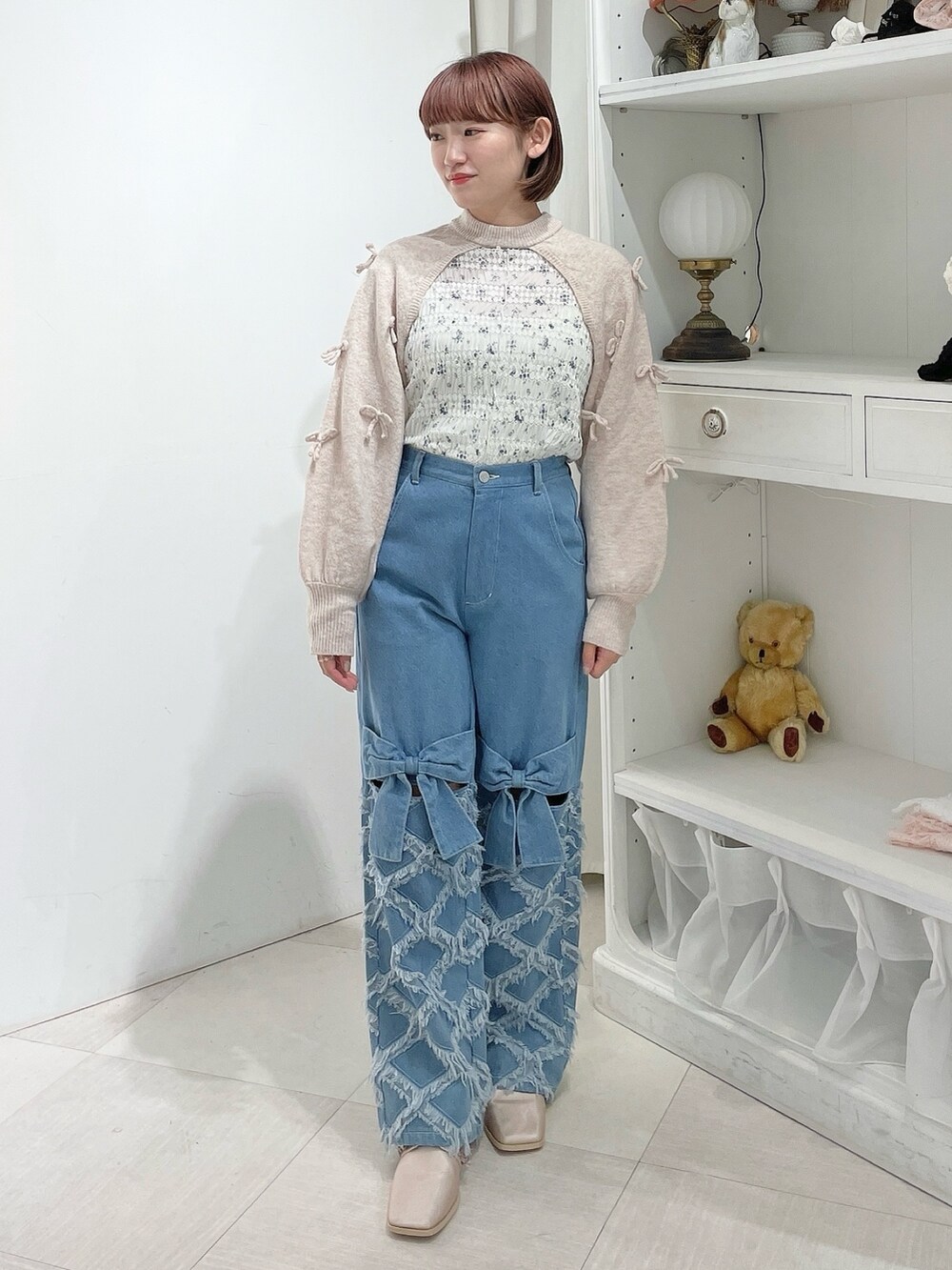 ホワイト系のTシャツ/カットソー、ピンク系のカーディガン/ボレロ、ブルー系のデニムパンツを着用したレディースの春コーディネートの2枚目の写真