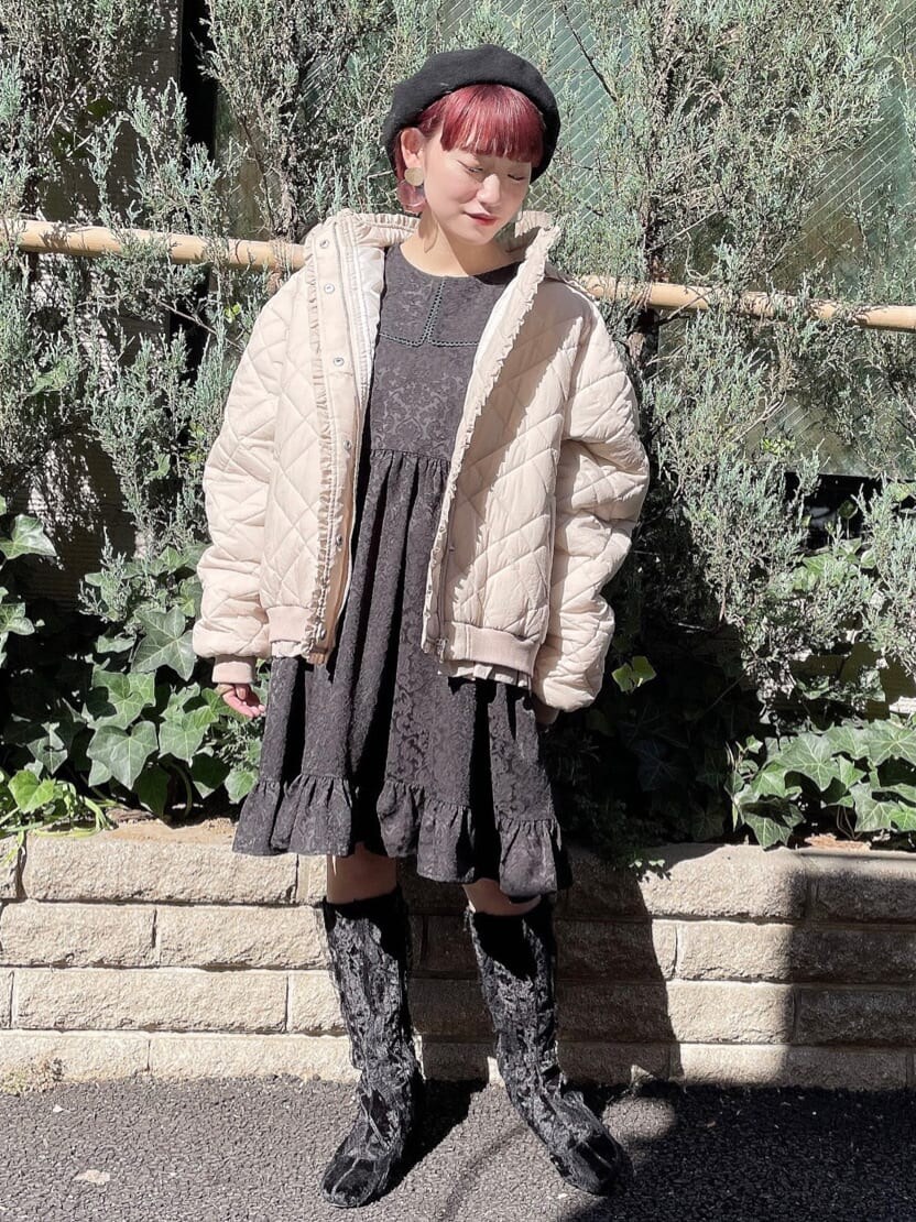 ホワイト系のナイロンジャケット、ブラック系のワンピースを着用したレディースの秋コーディネートの2枚目の写真