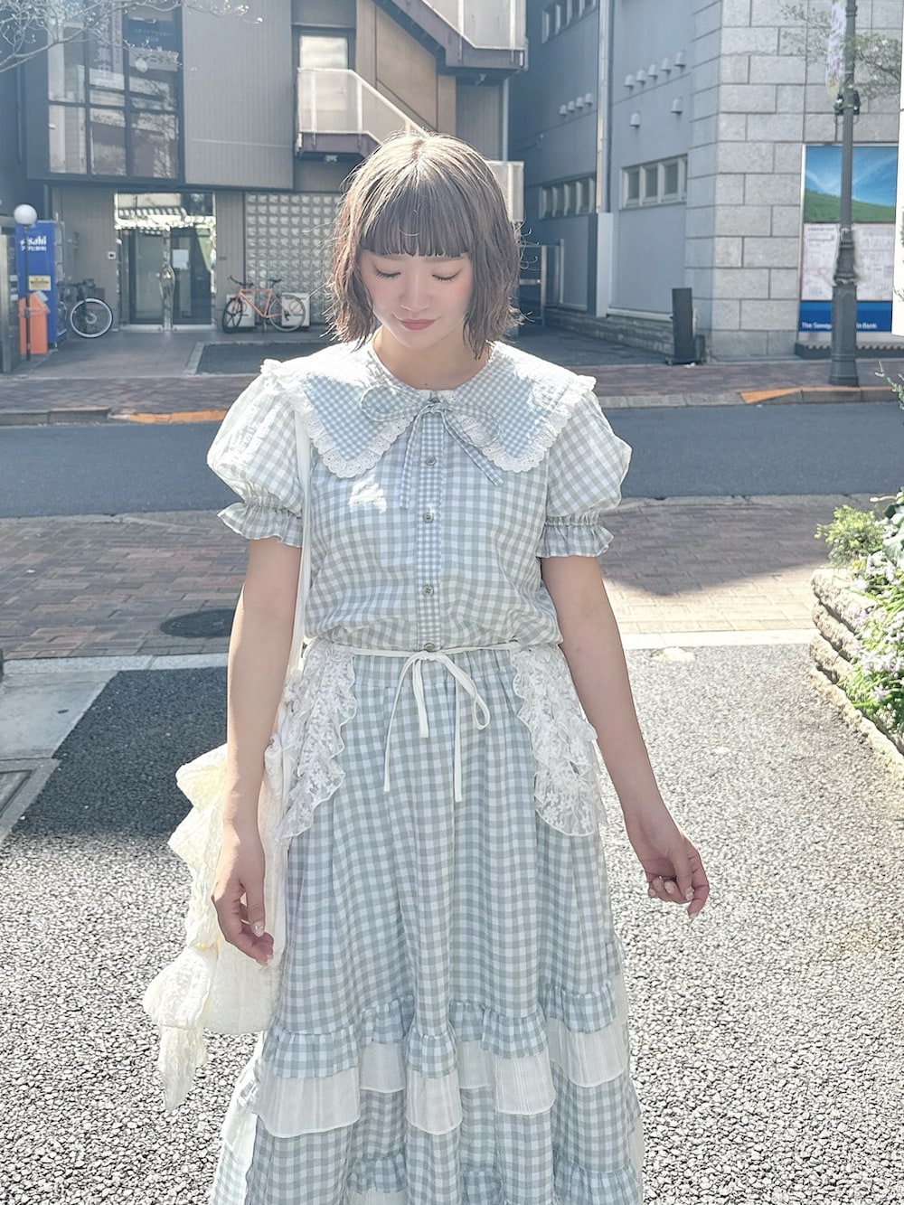 グリーン系のスカート、グリーン系のシャツ/ブラウス、ホワイト系のトートバッグを着用したレディースの春コーディネートの4枚目の写真