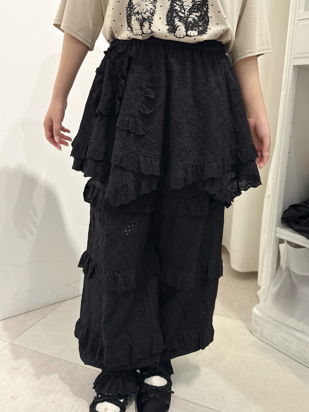 ベージュ系のTシャツ/カットソー、ブラック系のスカート、ブラック系のその他パンツを着用したレディースの春コーディネートの6枚目の写真