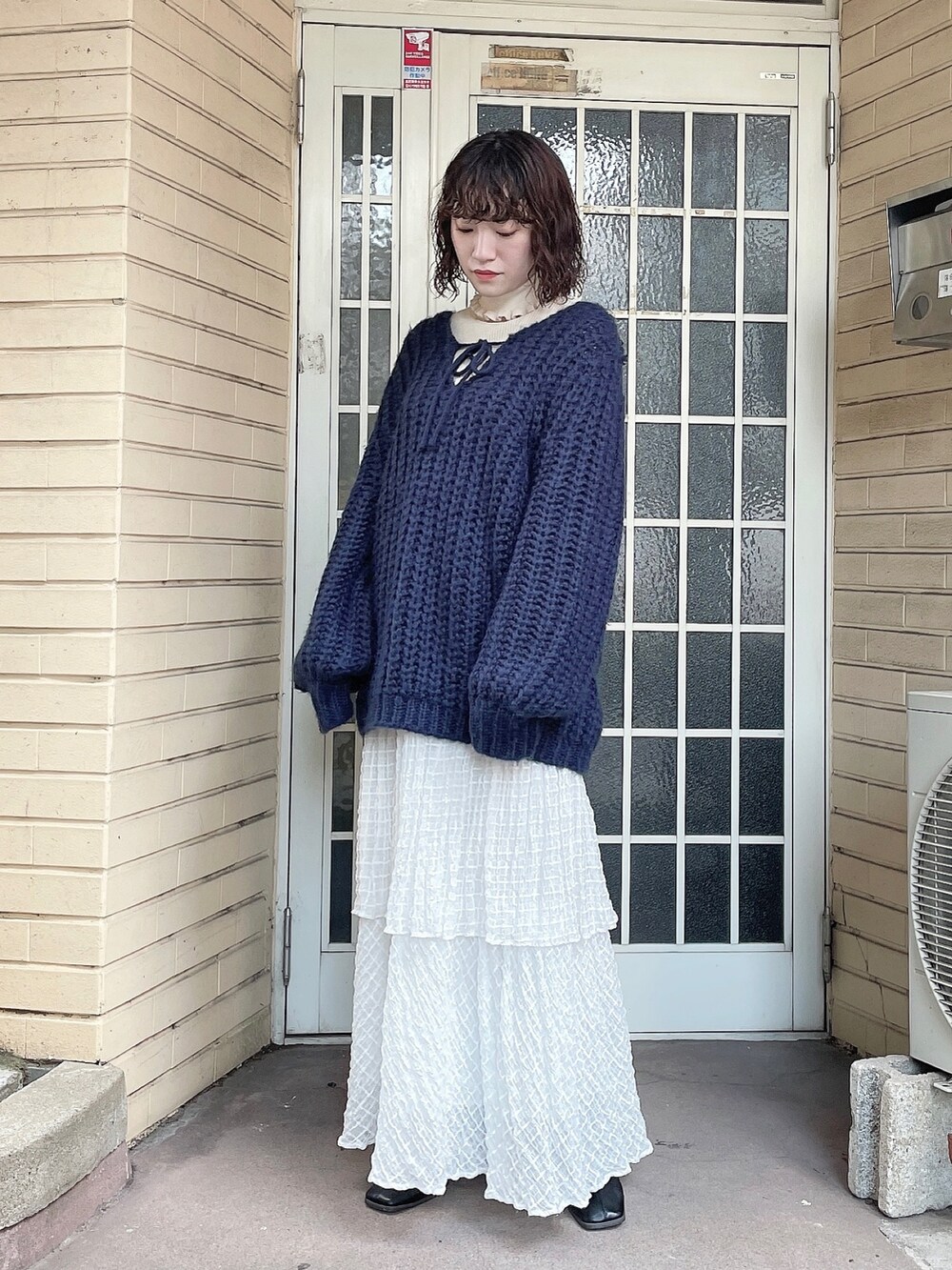 ブルー系のニット/セーター、ホワイト系のニット/セーター、ホワイト系のスカートを着用したレディースの秋コーディネートの2枚目の写真