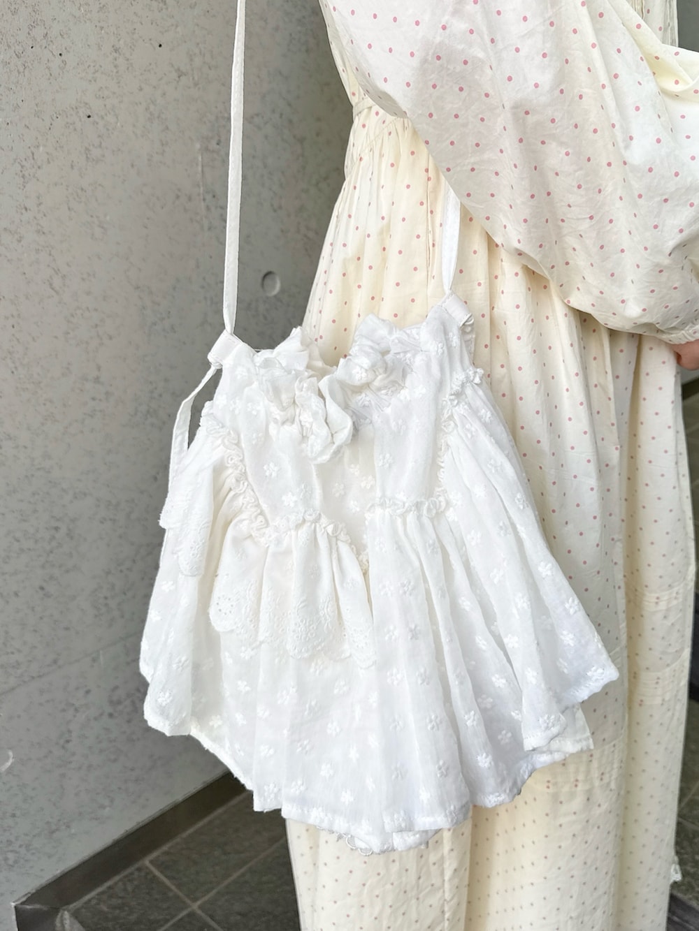 ベージュ系のワンピース、ピンク系のTシャツ/カットソー、ホワイト系のショルダーバッグを着用したレディースの春コーディネートの6枚目の写真