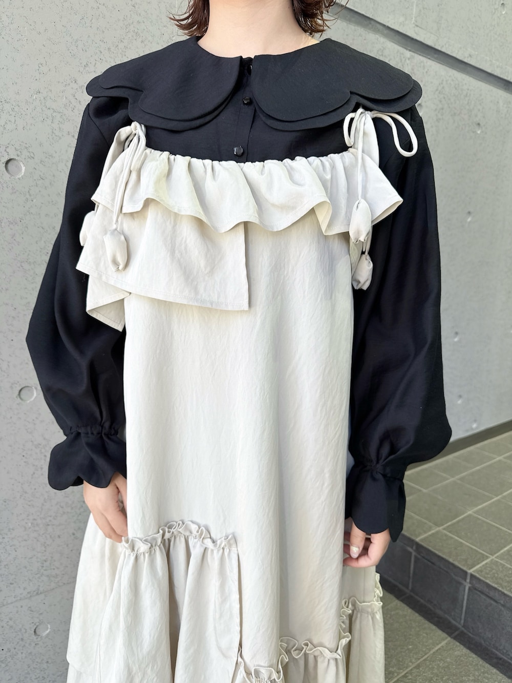 ベージュ系のワンピース、ブラック系のシャツ/ブラウス、ブラック系のショルダーバッグを着用したレディースの冬コーディネートの5枚目の写真