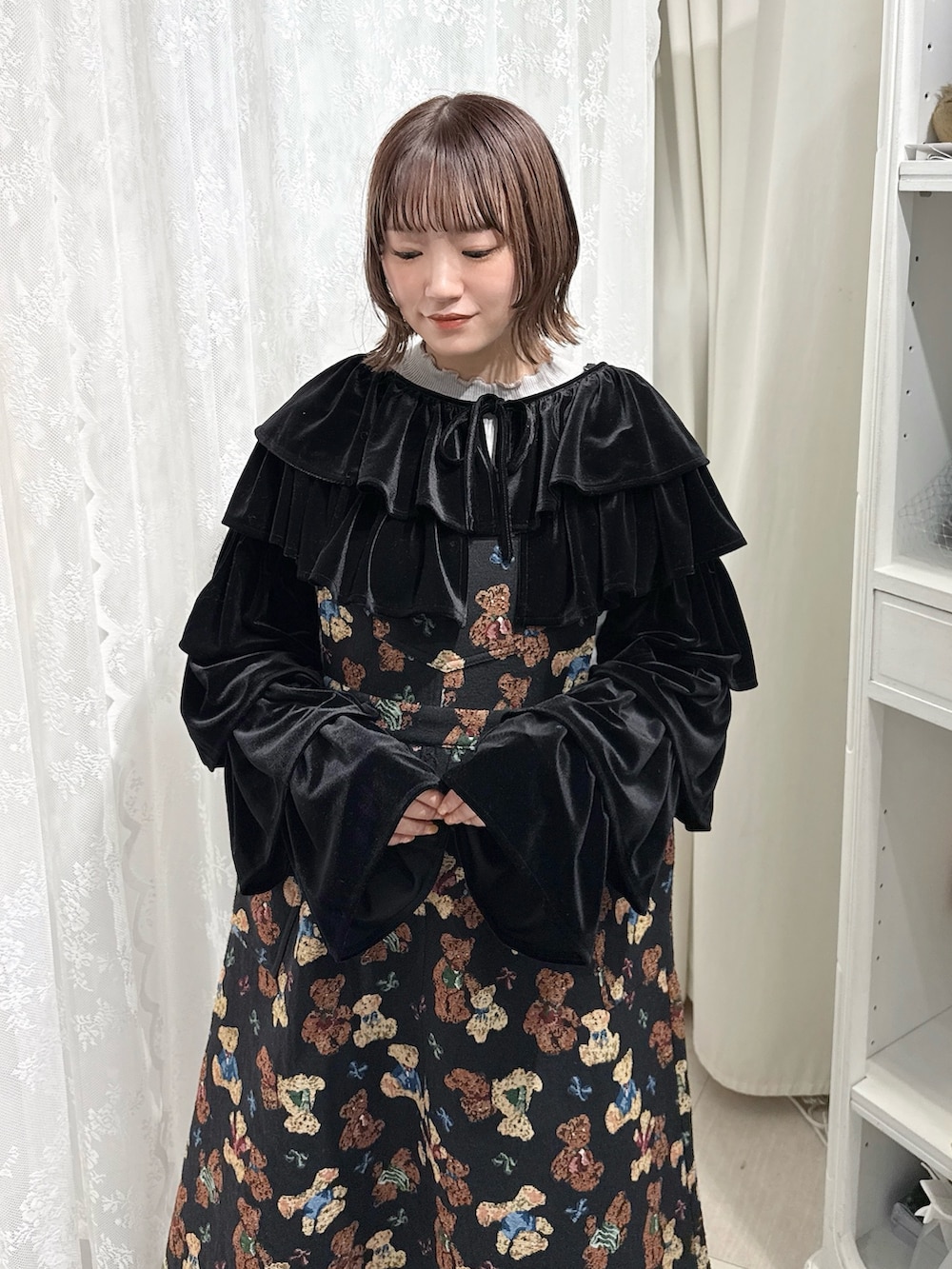 グレー系のニット/セーター、ブラック系のカーディガン/ボレロ、ブラック系のジャンパースカートを着用したレディースの秋コーディネートの4枚目の写真