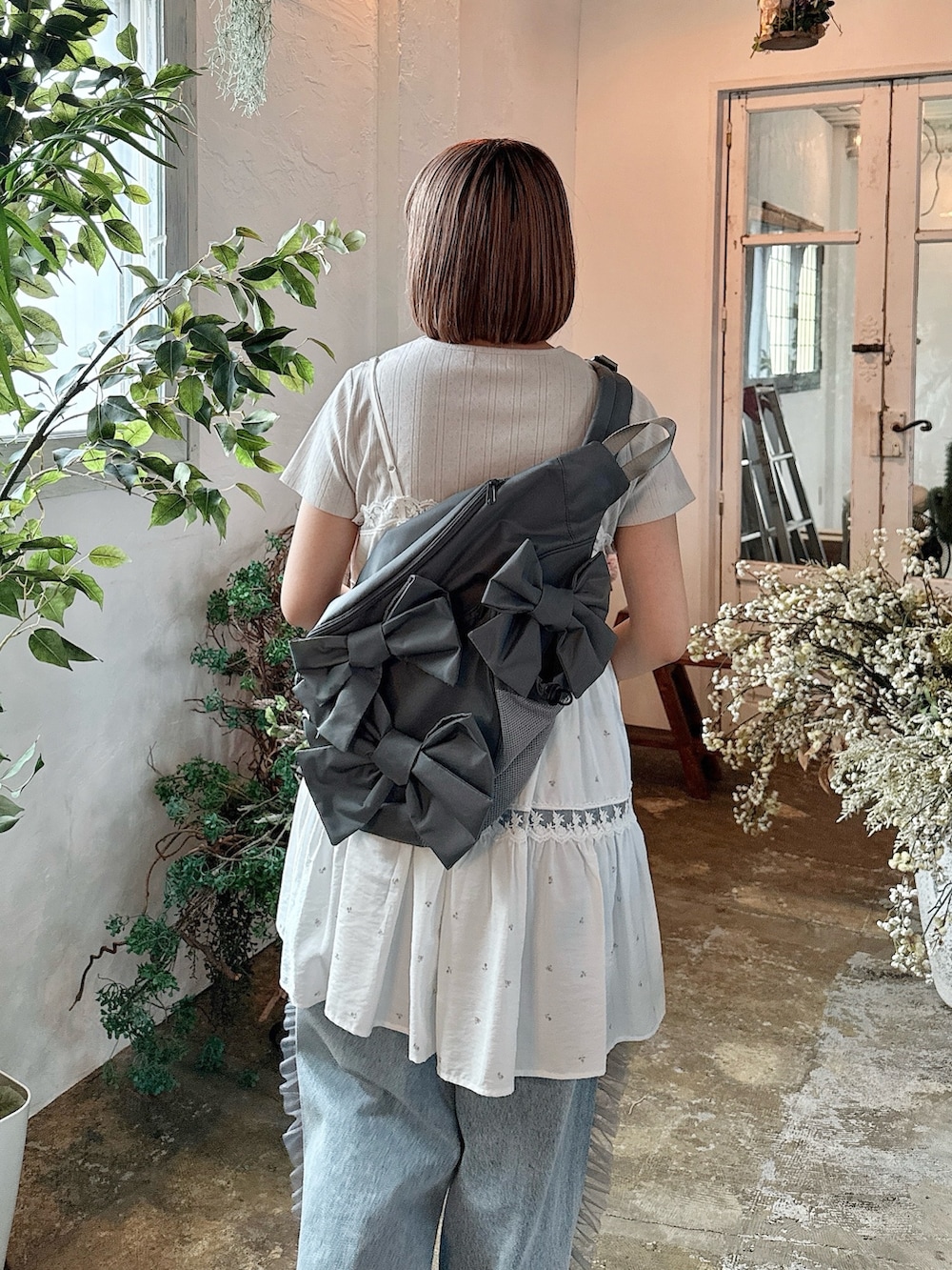 ピンク系のキャミソール、グレー系のショルダーバッグ、グレー系のTシャツ/カットソーを着用したレディースの春コーディネートの6枚目の写真