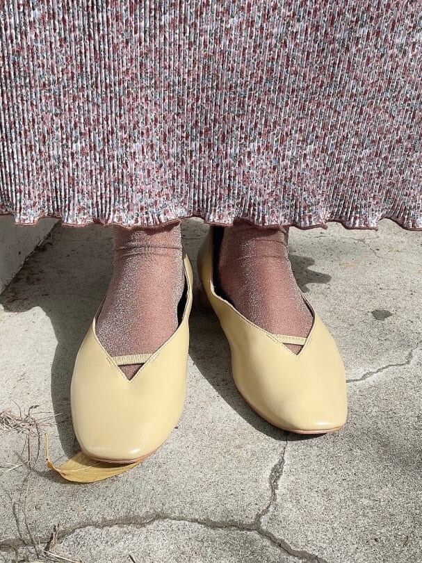 ブラウン系のワンピース、イエロー系のパンプス、ホワイト系のカーディガン/ボレロを着用したレディースの秋コーディネートの5枚目の写真