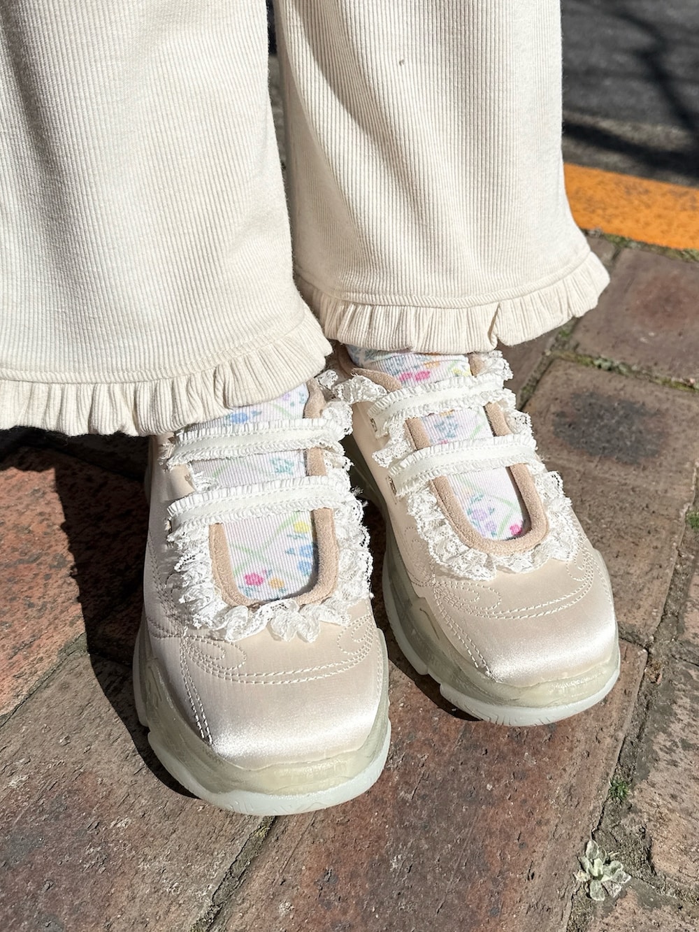 ホワイト系のスウェット、ベージュ系のメッセンジャーバッグ、ホワイト系のスウェットパンツを着用したレディースの冬コーディネートの6枚目の写真